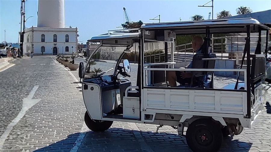 Tuk tuk next to La Farola lighthouse in Málaga's port
