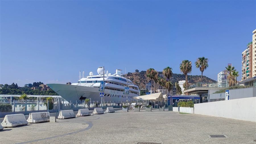 Luxury yacht docked at Málaga Port with city views
